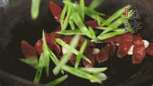 先后下香腸片、四季豆絲均勻翻炒，加適量清水燜煮一下。