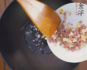 油溫3成熱時(shí)，下火腿丁、筍丁炒出香味，放豌豆粒翻炒均勻2分鐘。