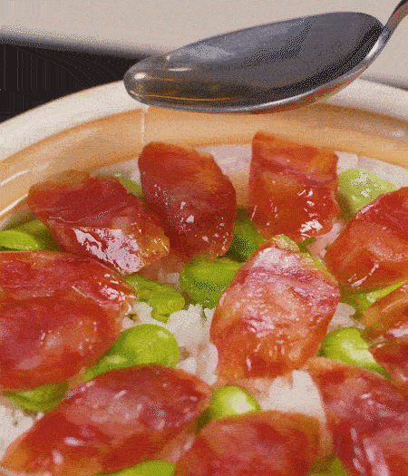 大米出現小孔時開蓋放香腸，往鍋邊淋入少許油，再燜煮8~10分鐘左右。