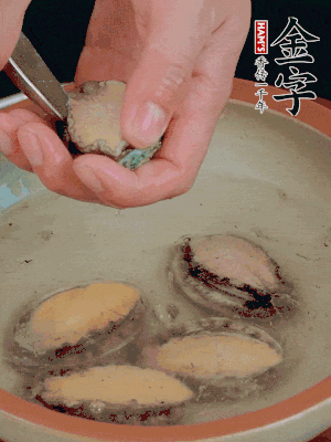 鮑魚加鹽、清水浸泡，用勺子挖出鮑魚肉。