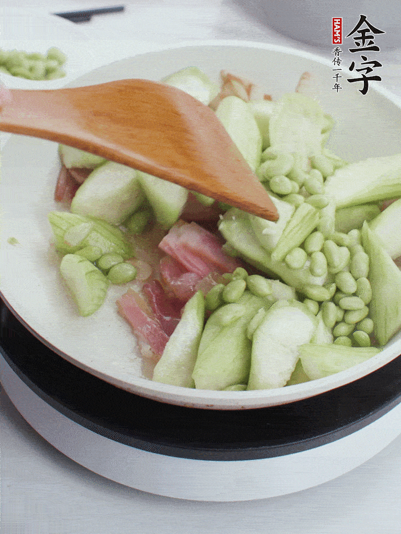 依次下絲瓜、青豆翻炒，炒至絲瓜打蔫縮小。