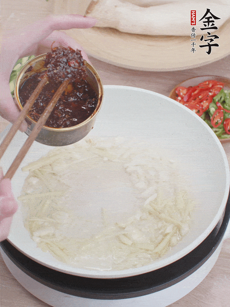 起鍋熱油，姜蒜、金字火腿干貝醬煸香。