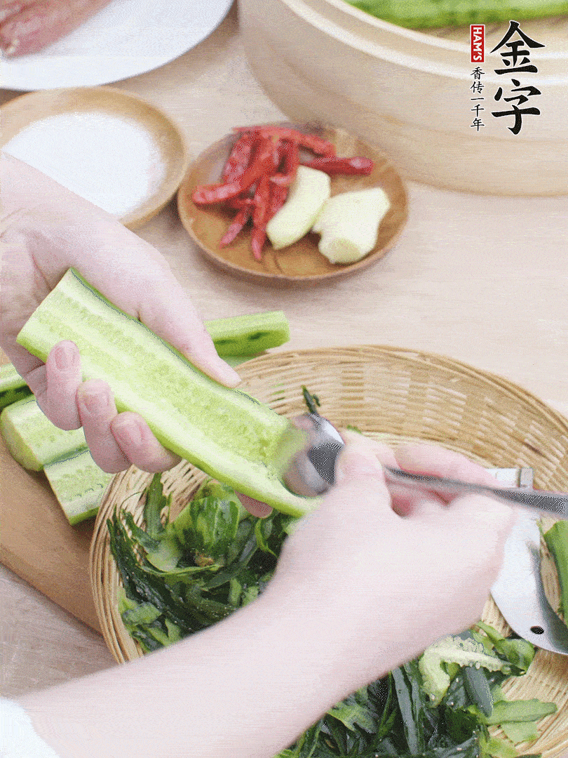 黃瓜削皮，對半切開，勺子挖去內瓤，斜刀切片。青蒜斜刀切段。