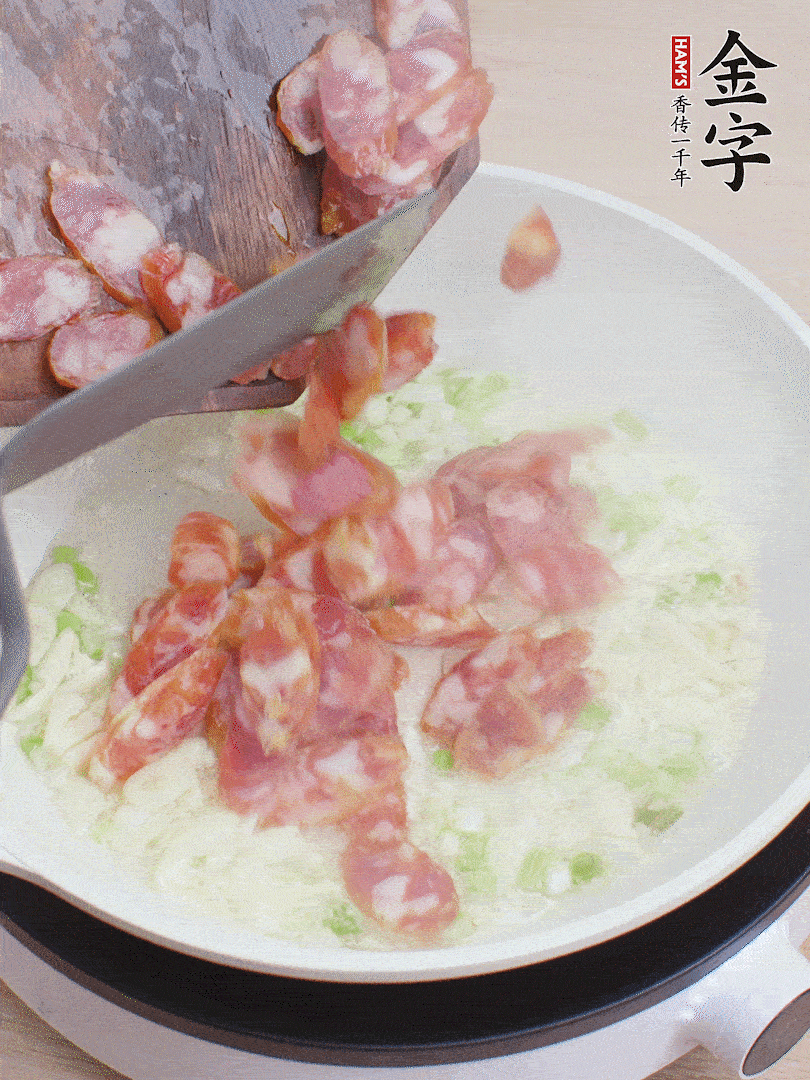 油5成熱，蒜末、蔥白爆香，下香腸炒出香味。