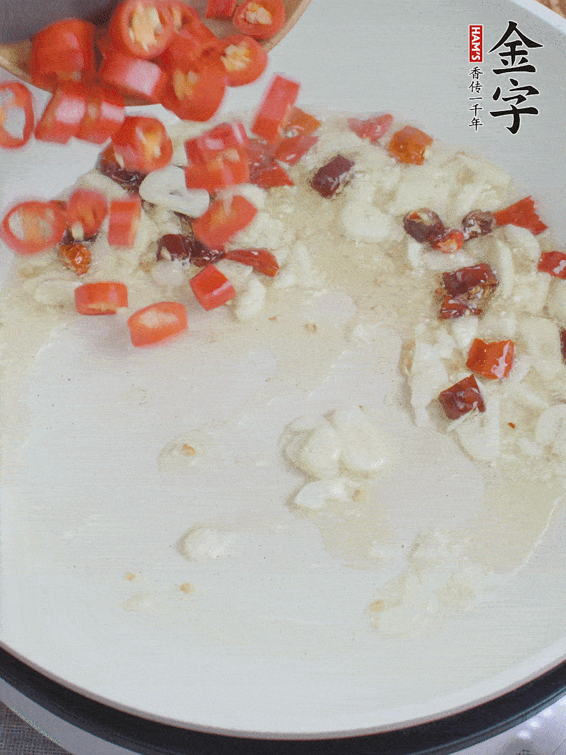 油6成熱，下蒜末、干紅辣椒煸炒，出香味后再放美人椒、香腸。