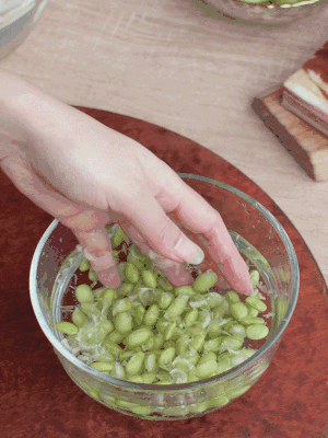 青豆剝殼，搓去外衣。