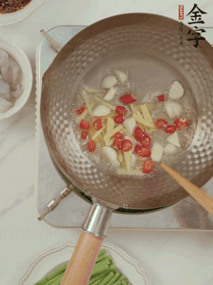 油7成熱時(shí)，下大蒜粒、姜絲、小米辣煸香。