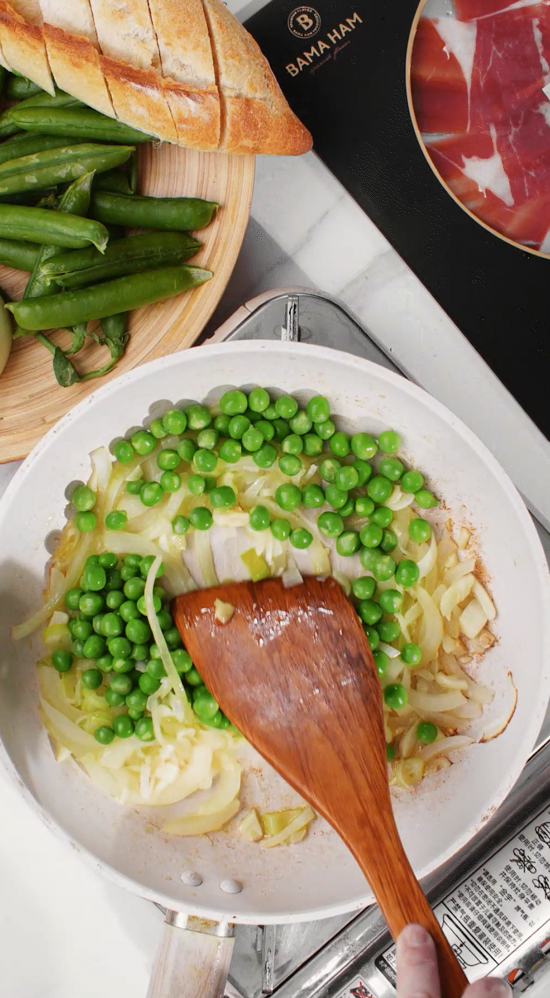 鍋中放入黃油融化，加入洋蔥絲、大蔥蔥白絲、蒜末翻炒變軟出香味。加入剛剛汆燙冰鎮(zhèn)后的豌豆，取出一點(diǎn)點(diǎn)待會擺盤裝飾用。加一點(diǎn)鹽 (和黑胡椒) 調(diào)味。